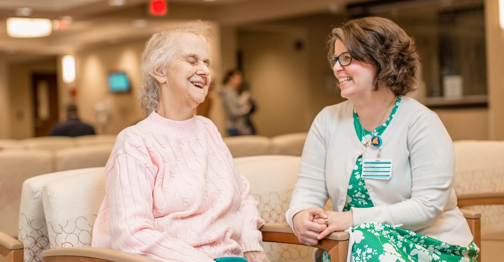 Patient and health care provider seated together in a lobby setting