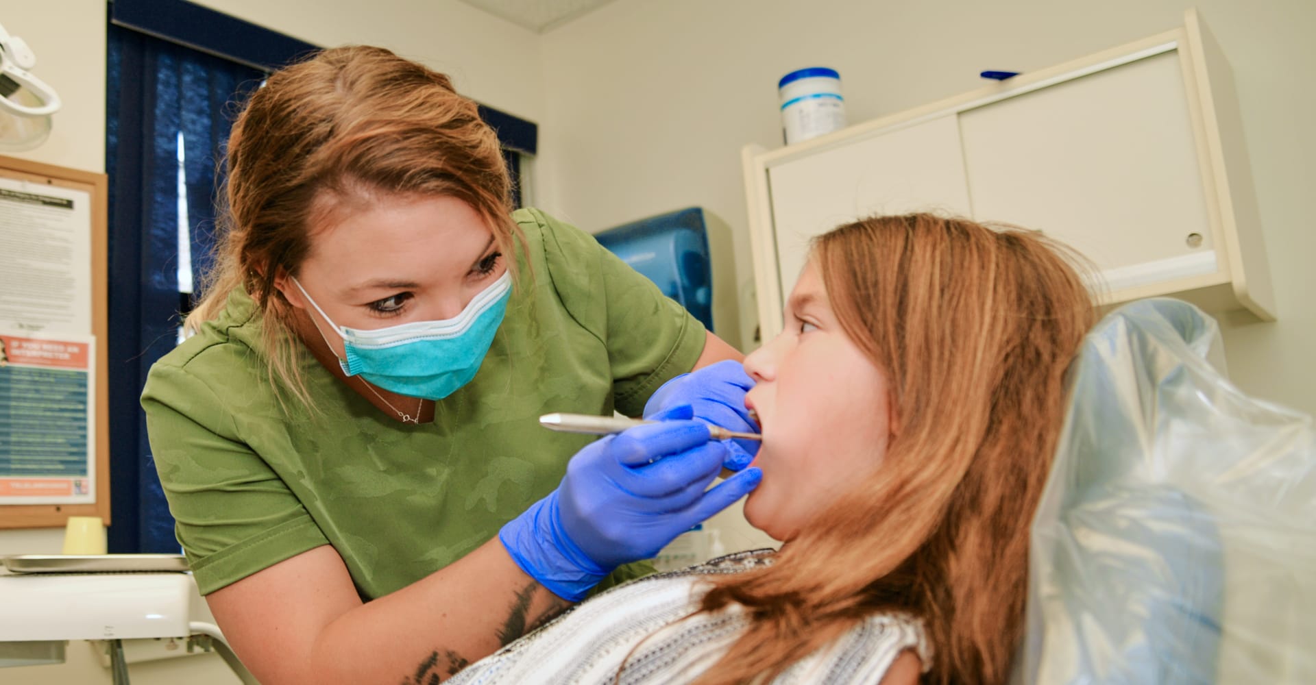 A dentist performing a procedure on a seated patient