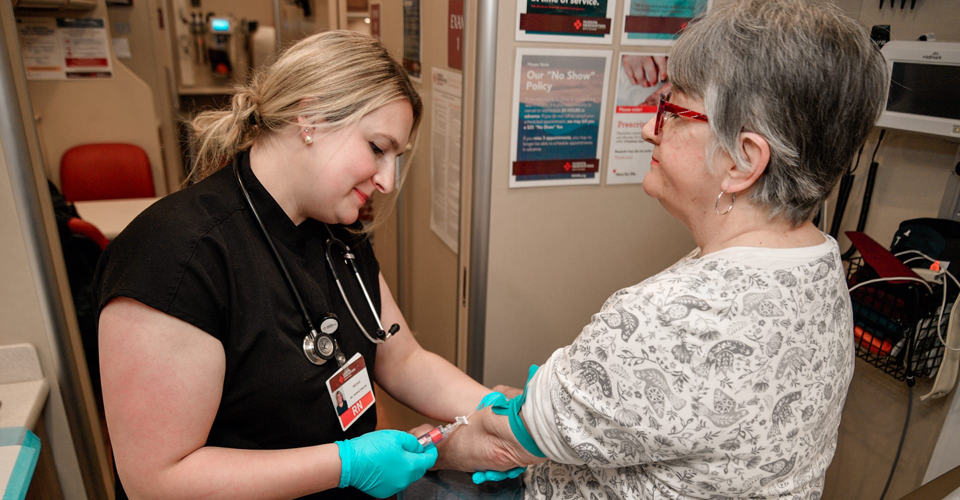 A registered nurse drawing blood from a patient