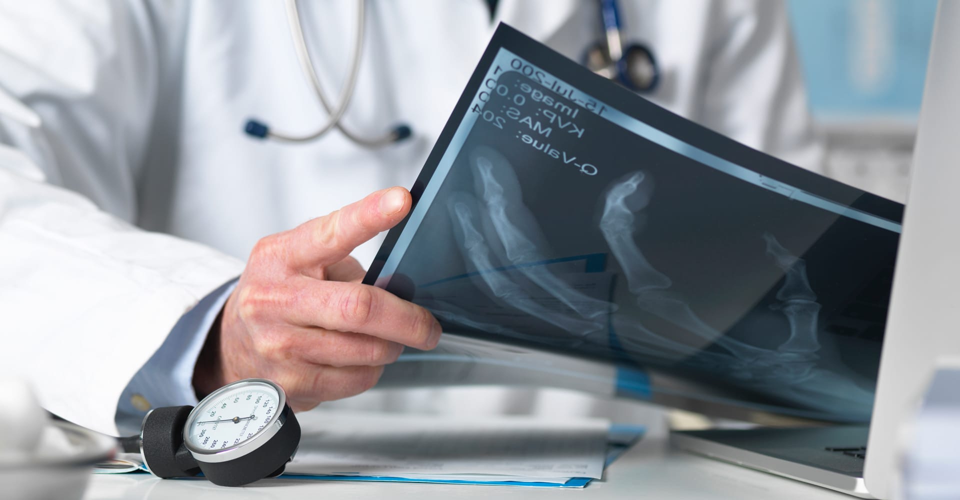 A health care provider examining an X-Ray of a patient’s hand