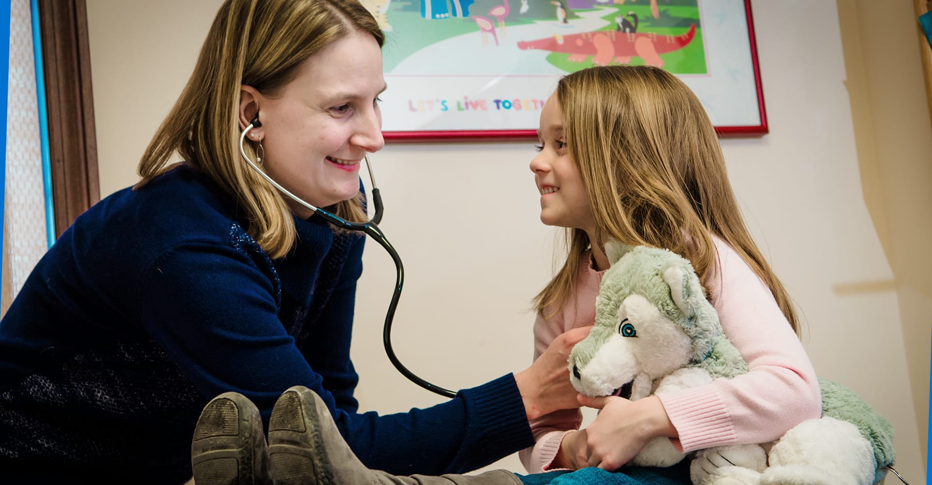 A health care provider using a stethoscope to listen to the chest of a young patient