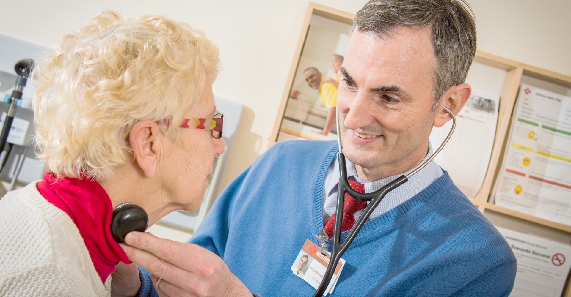 A health care provider listening to a patient’s heart rate with a stethoscope