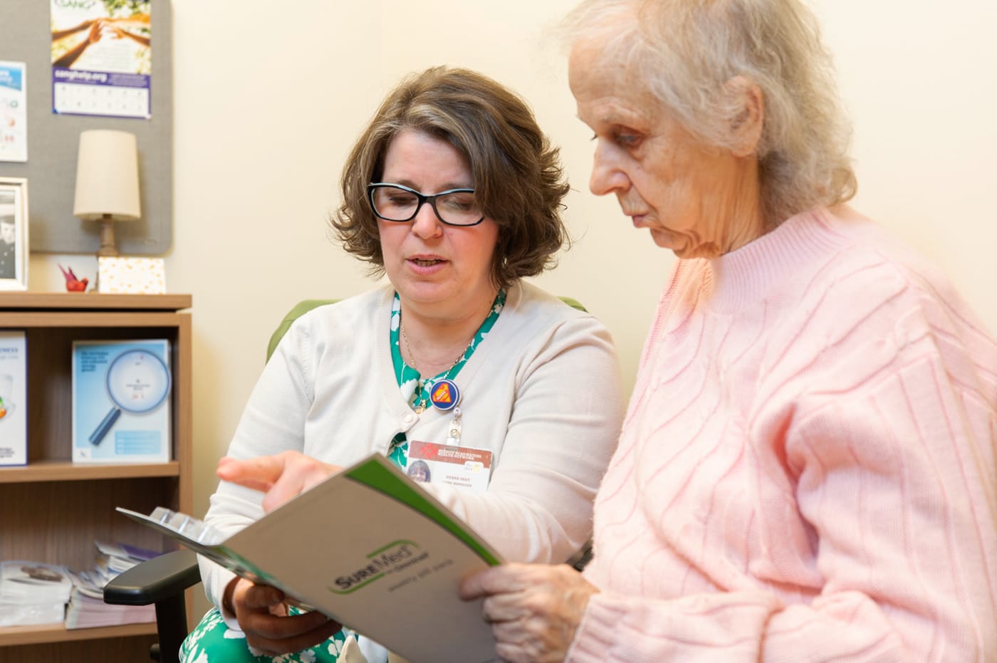 A health care provider and patient reviewing printed materials