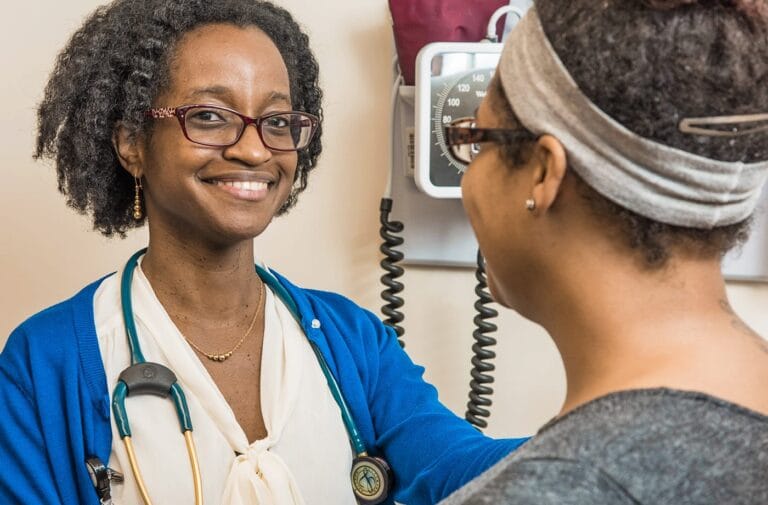 A health care provider and patient in an exam setting