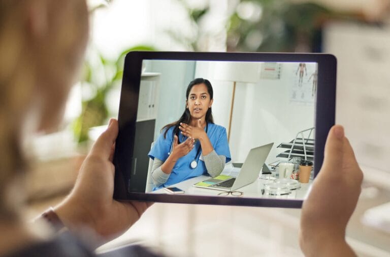A patient holding a tablet with during a Telehealth appointment