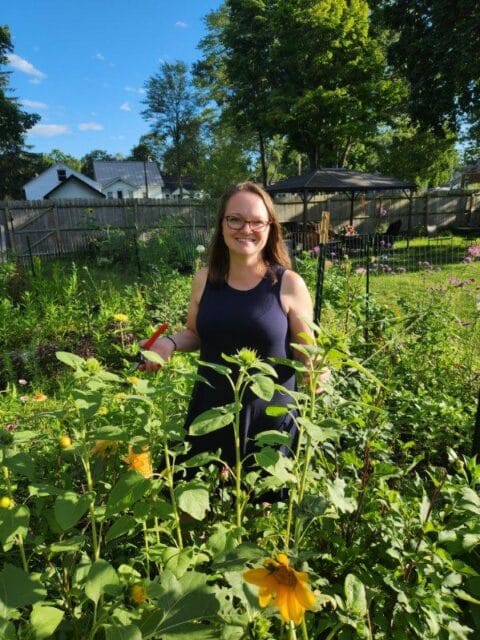 Elisia Barber, FNP standing in a garden