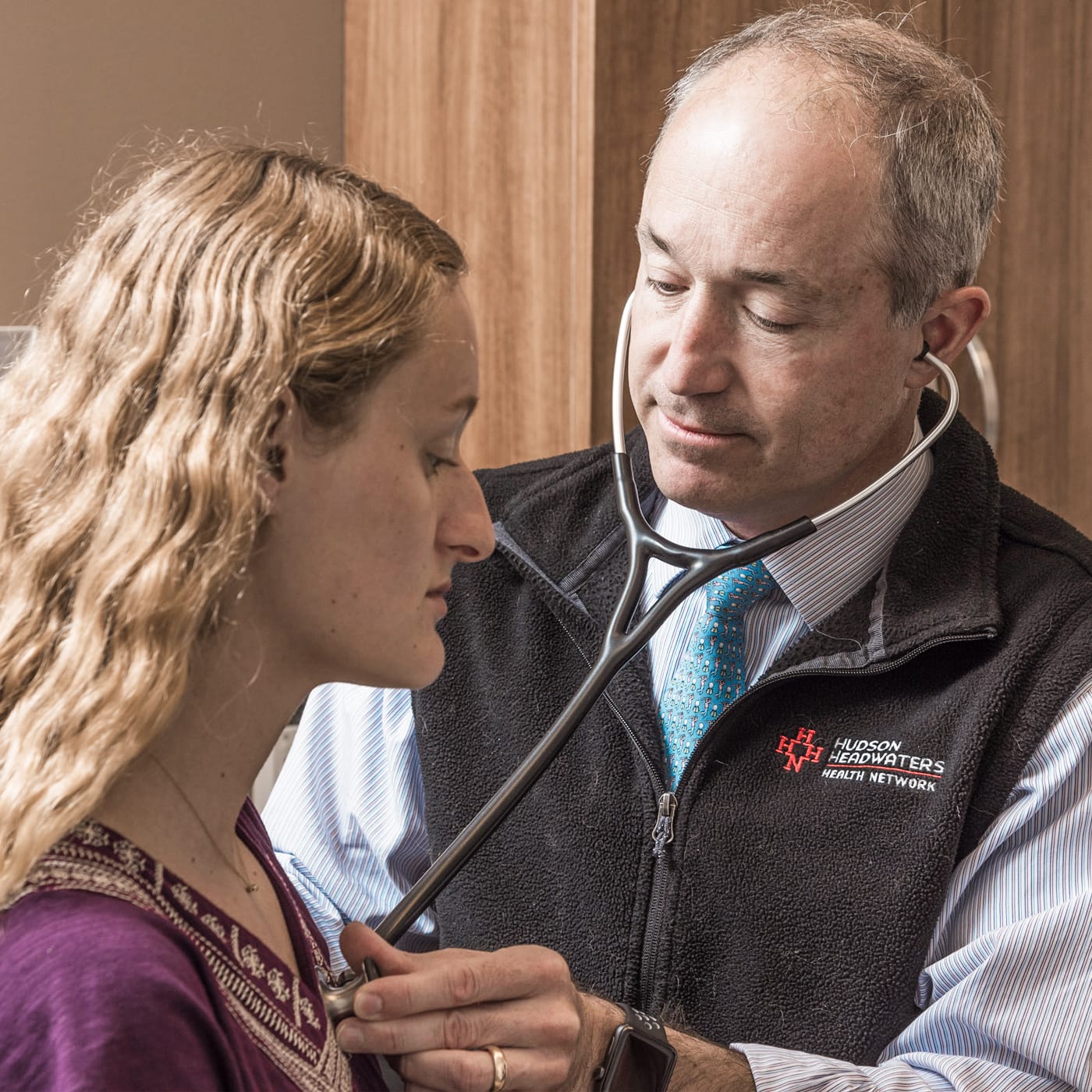 A doctor listening to a patient’s chest via stethoscope