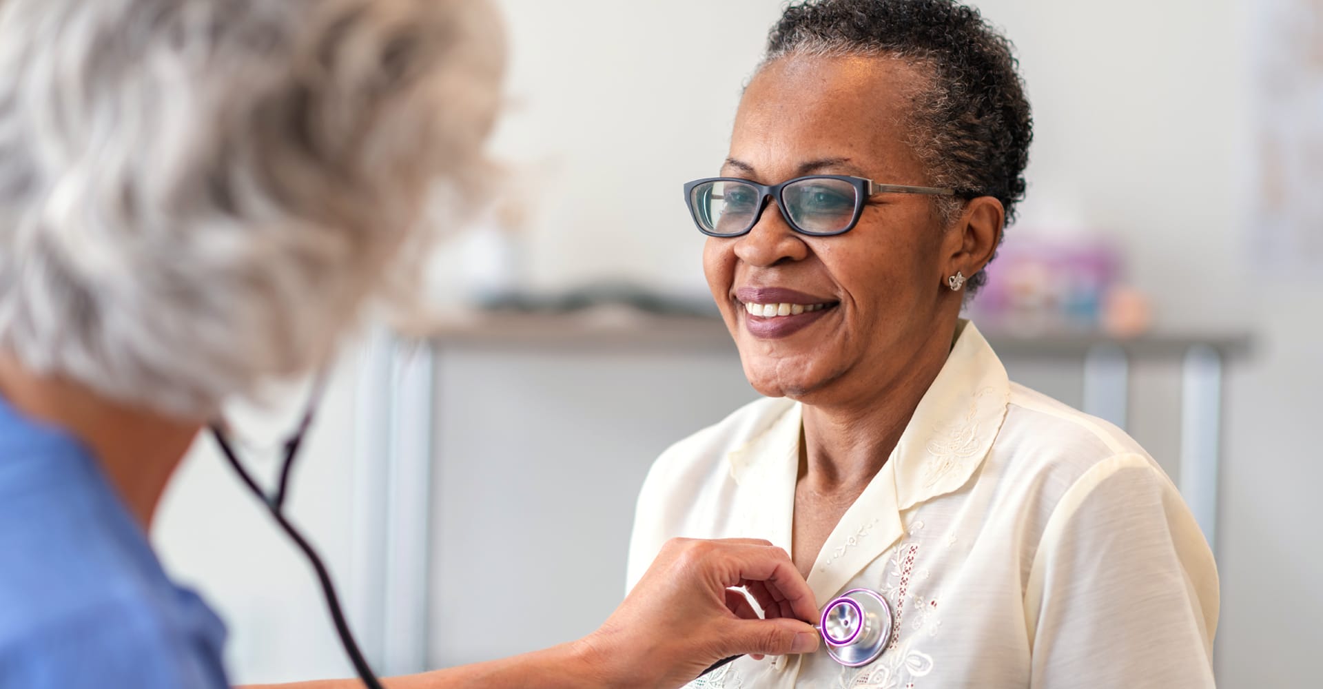 A doctor listening to a patient’s chest with a stethoscope