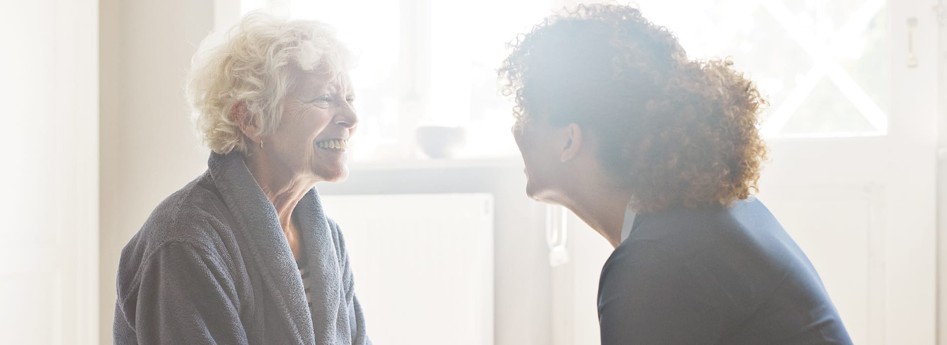 A health care provider holding hands with a senior patient