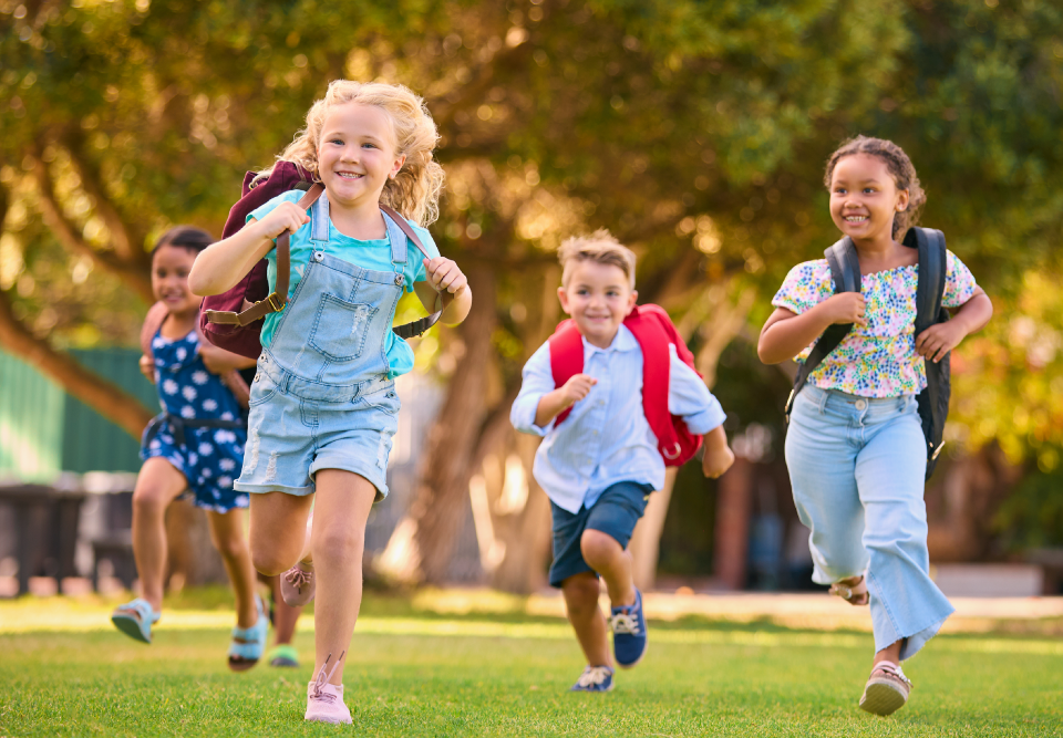 Kids with backpacks running outside