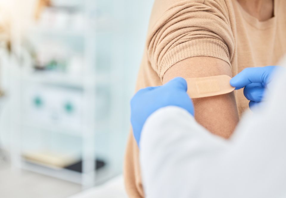 medical professional putting a bandage on a patient