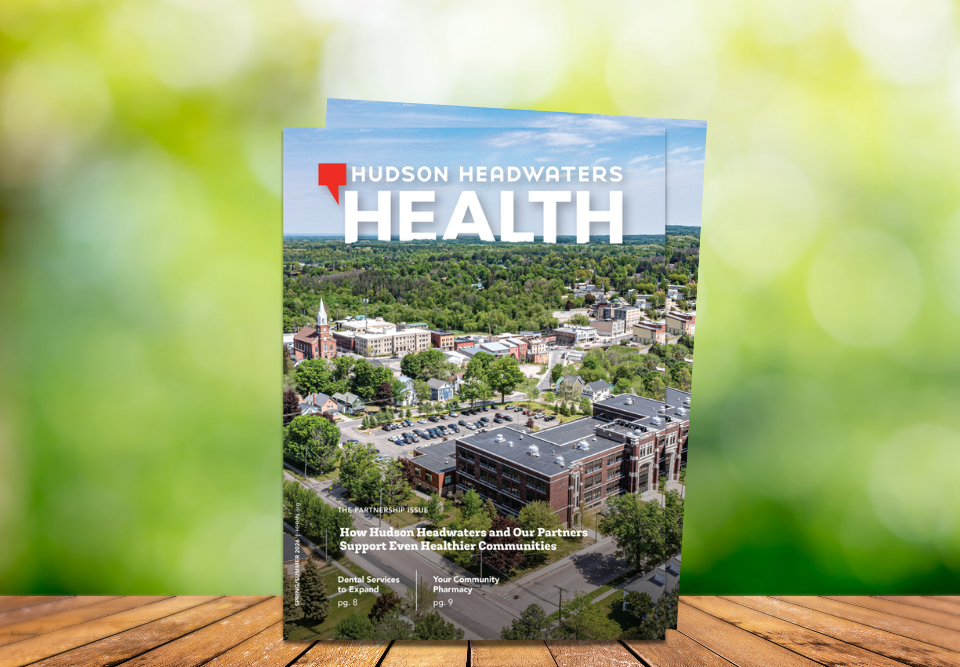Cover of the Spring/Summer 2026 issue of Hudson Headwaters Health on a wooden table in front of trees