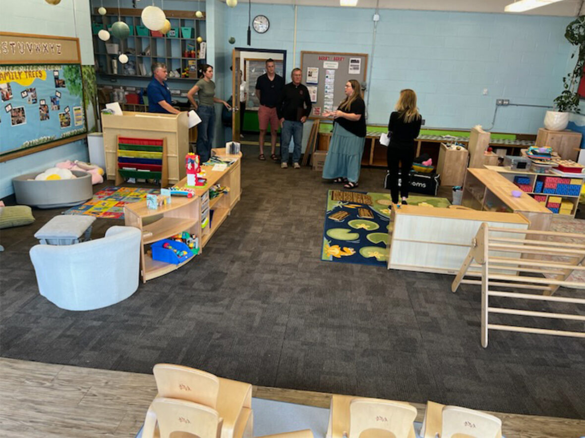 Group of people getting a tour of a daycare classroom.