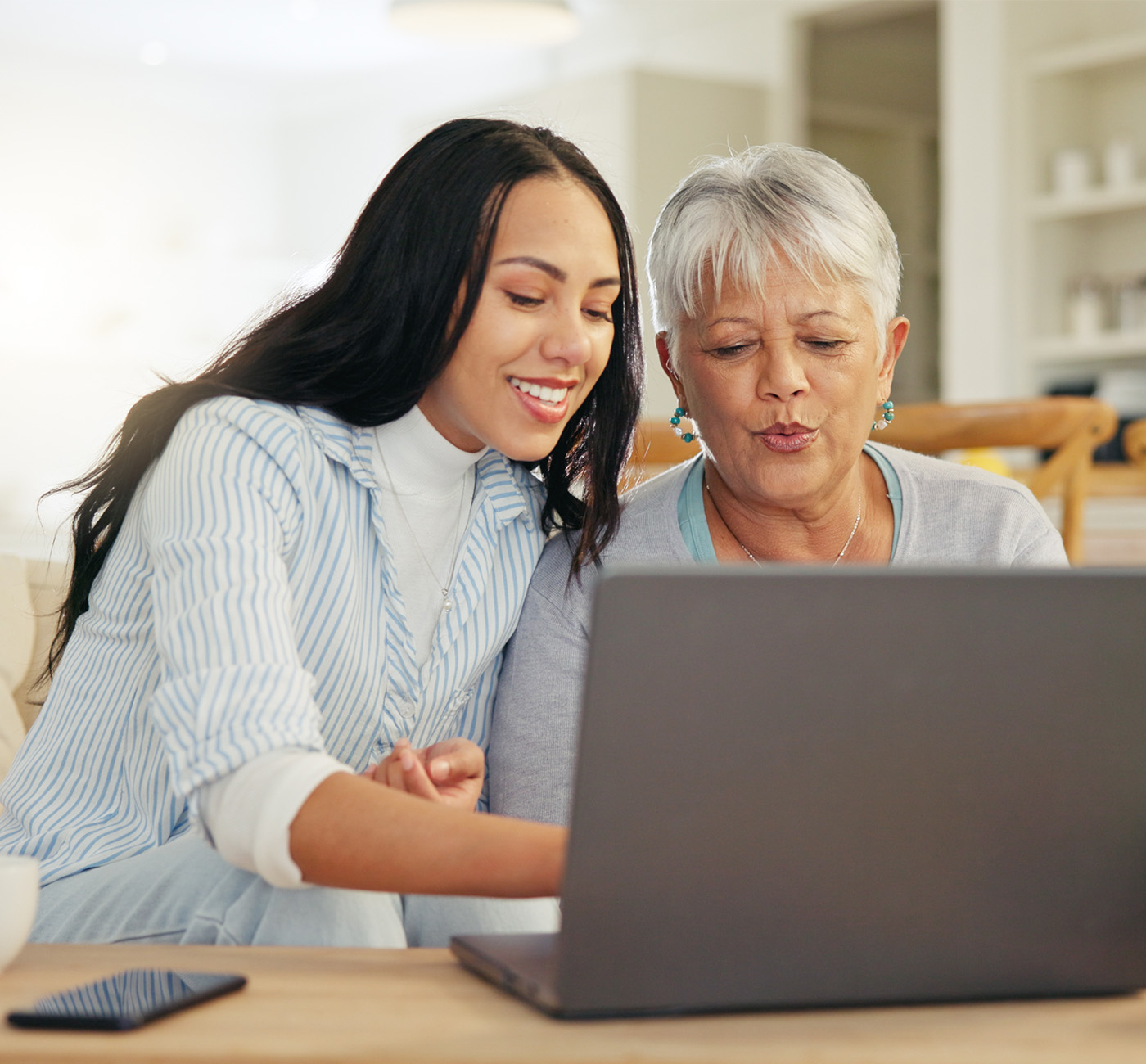 Younger woman helping older woman with the computer
